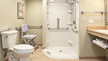 A practical bathroom scene showing grab bars mounted near key areas, designed to enhance senior safety and independence.